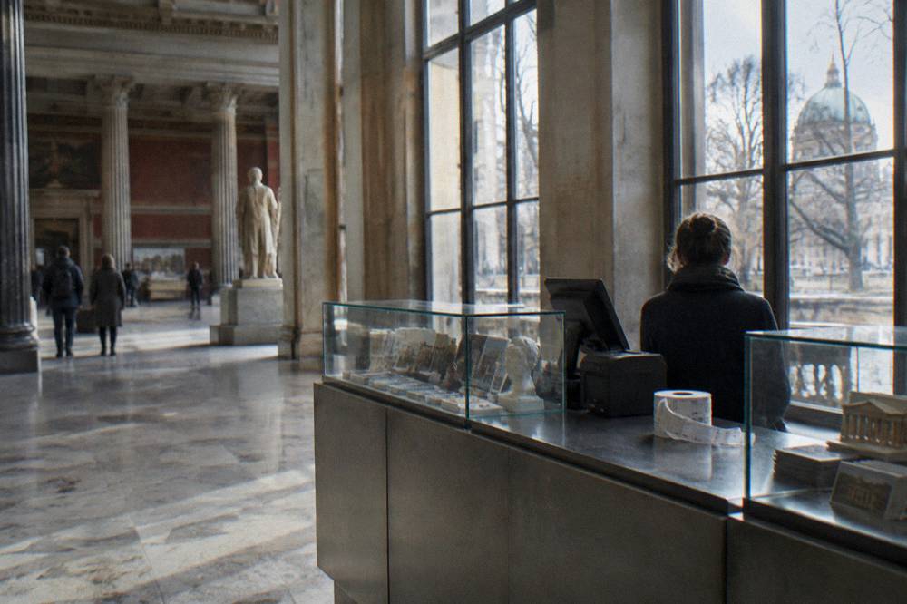 Ticket counter and glass display cases inside a brightly lit museum hall