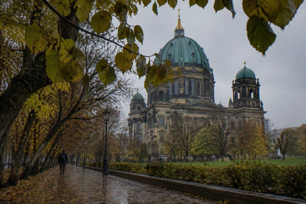 The domed roof and green copper details of Berlin Cathedral above the trees