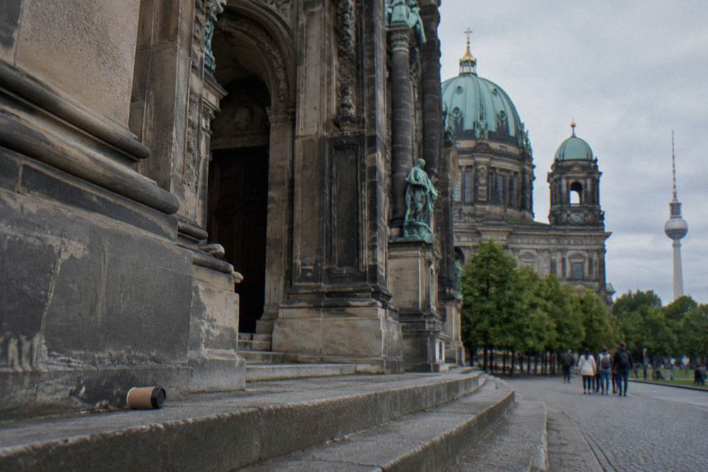 The stone facade and arched entrance of Berlin Cathedral seen from the square