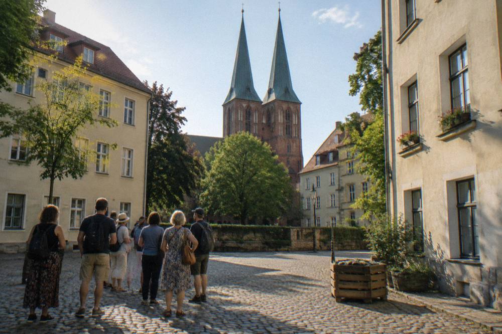 A walking group gathered at an open square in central Berlin on a sunny afternoon
