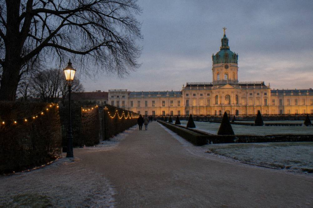 Winter evening lights over a Berlin public square with historic facades