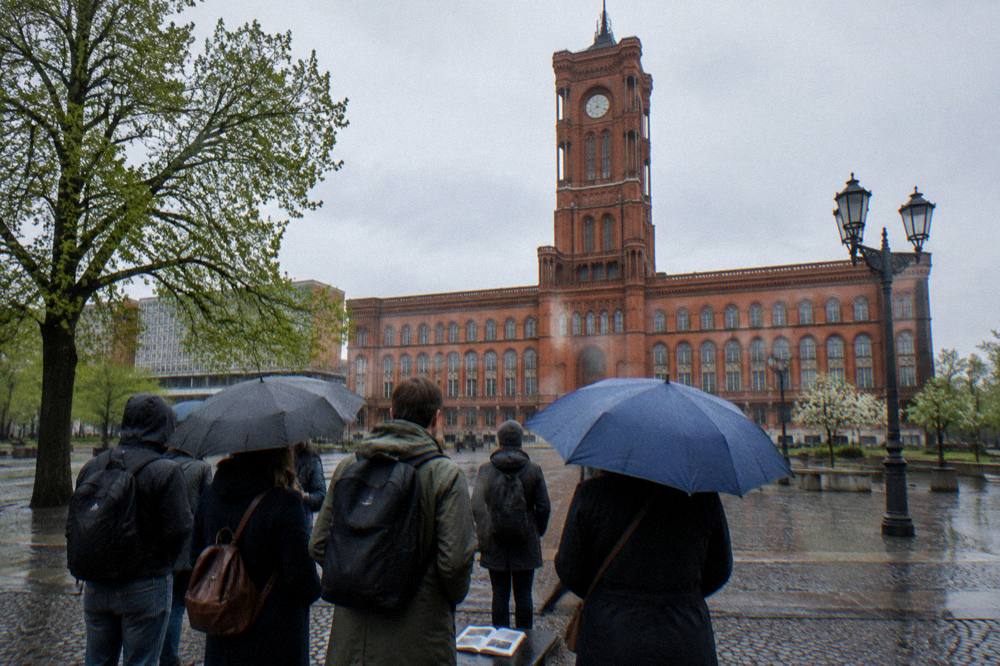 A walking tour group gathered at a city square meeting point beside historic buildings