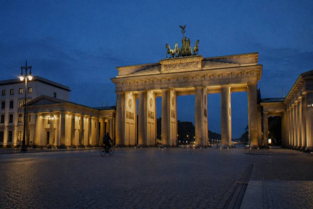 The Brandenburg Gate lit softly against a dark evening sky with the square quiet around it