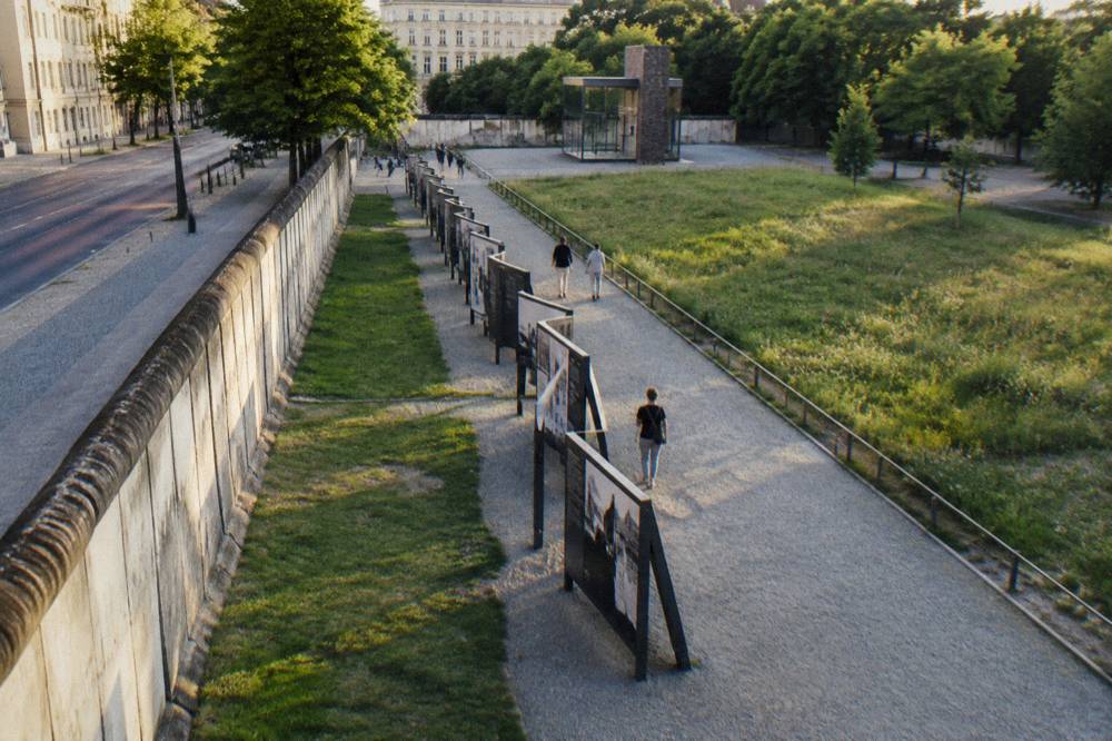 Outdoor exhibition panels standing along a Berlin street with grass in front