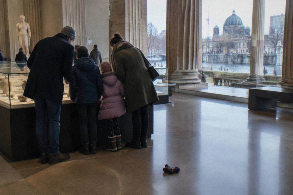 Family reading a museum display case together in a bright gallery