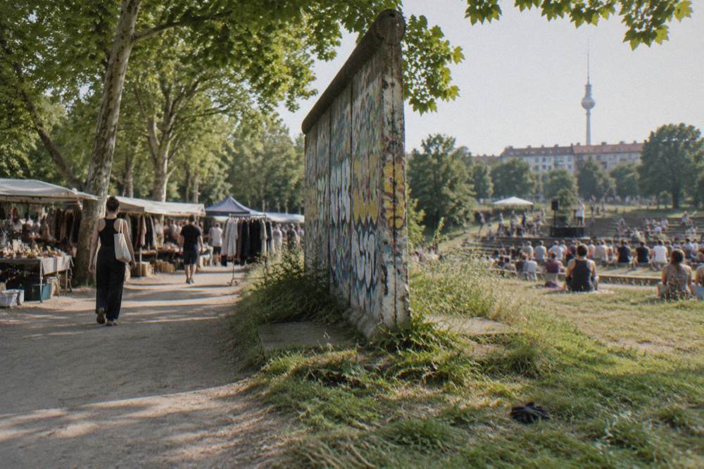 A preserved section of the Berlin Wall beside an open-air exhibition