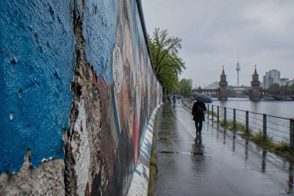 Long stretch of painted concrete wall beside a walkway in Berlin