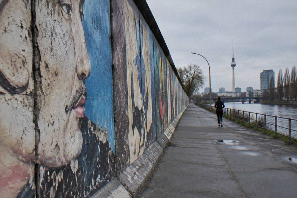 Row of murals on a low concrete wall under open sky in Berlin