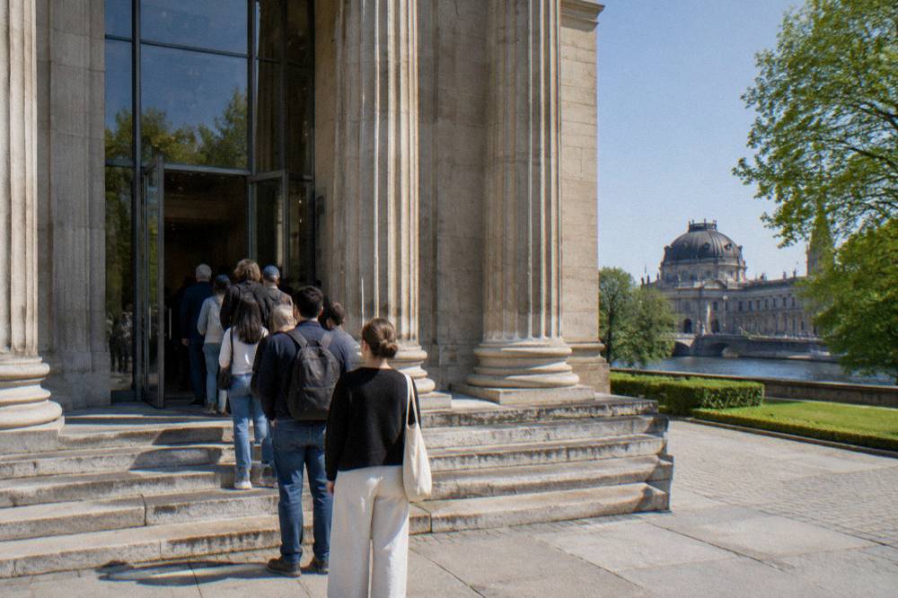 Museum ticket desk with visitors queueing in a bright entrance hall