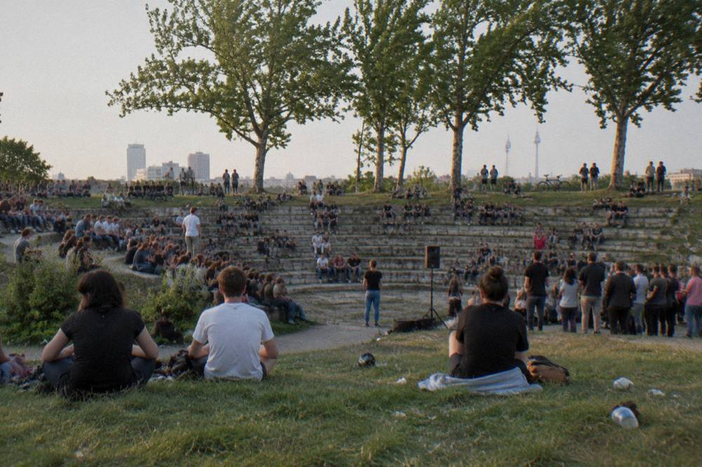 Open grassy strip of Mauerpark with the crowd gathered for Sunday karaoke