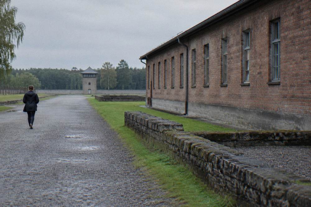 Exhibition panels along a path at the Sachsenhausen Memorial with text displays in front of a plain brick wall