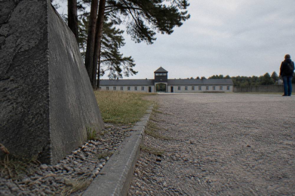 A quiet memorial stone and gravel pathway at Sachsenhausen under an overcast sky