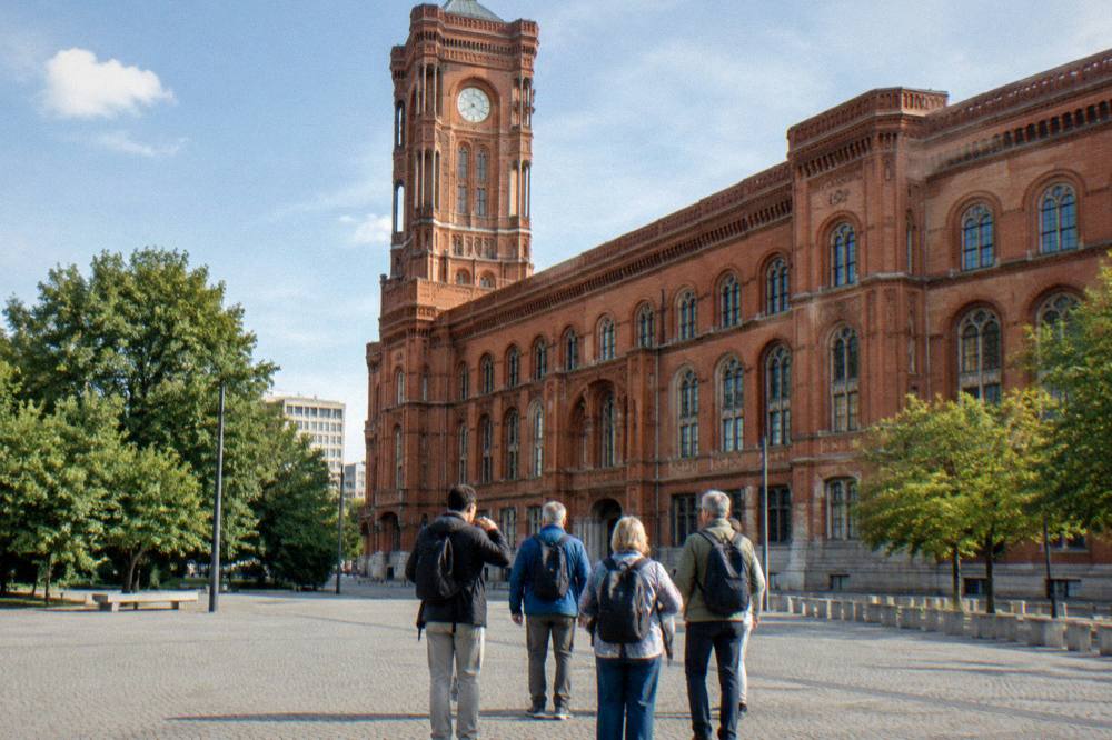 A group of walkers standing with a guide at a Berlin square on a free walking tour