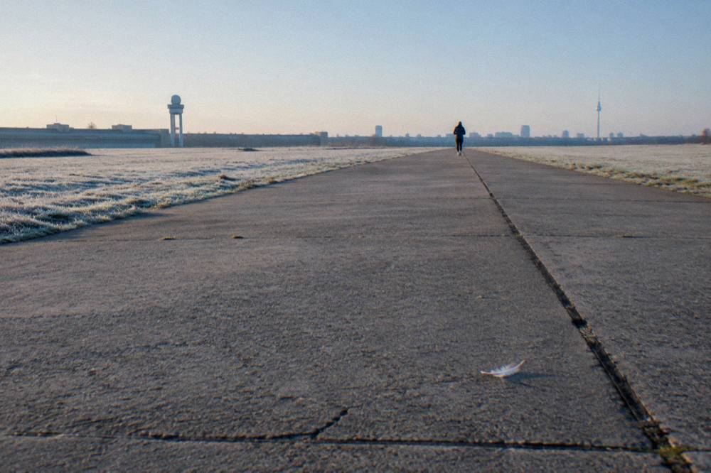 Long straight former taxiway framed by grass on both sides