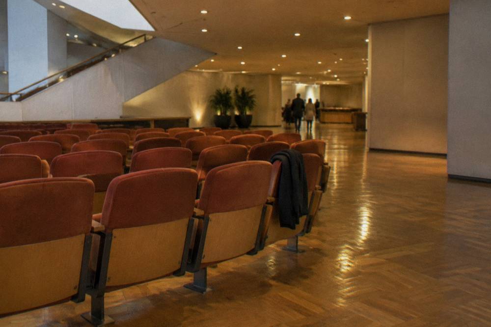 Classical concert hall foyer with rows of seats under warm lighting